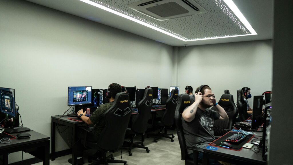 Group of gamers intensely playing video games in a modern esports center.